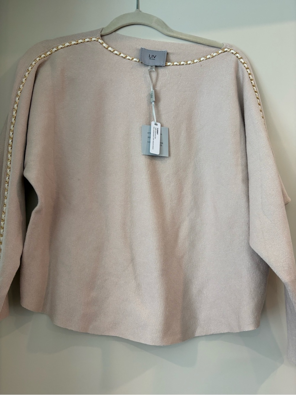 LIV Milano Knit Top in Winter White. Gold and white band around the sleeves..